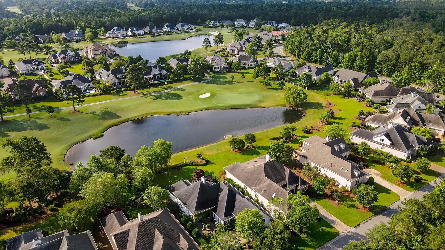 Aerial view of ponds, golf greens, and residential streets in Landfall