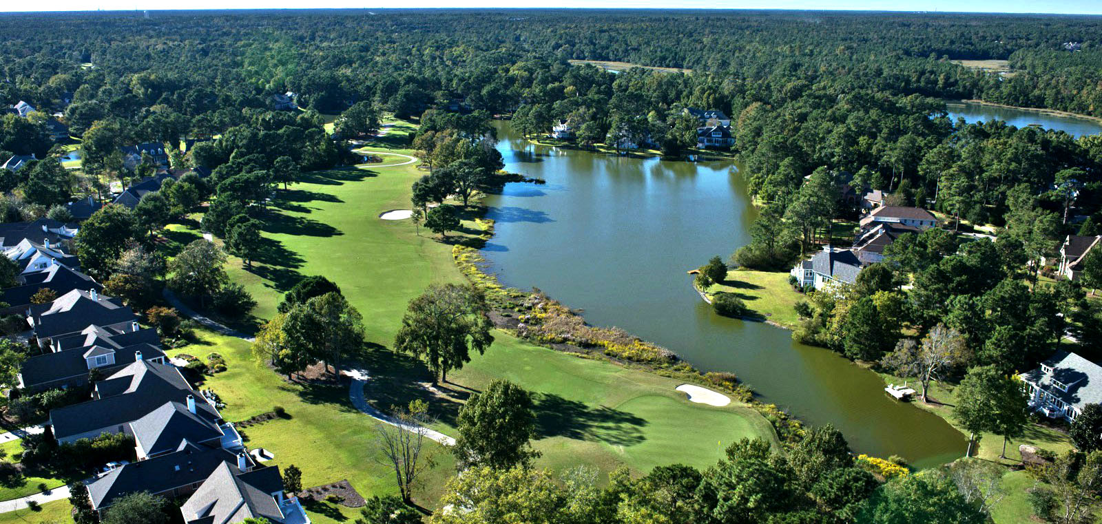 Aerial view of homes, fairways, and a pond in Porters Neck Plantation