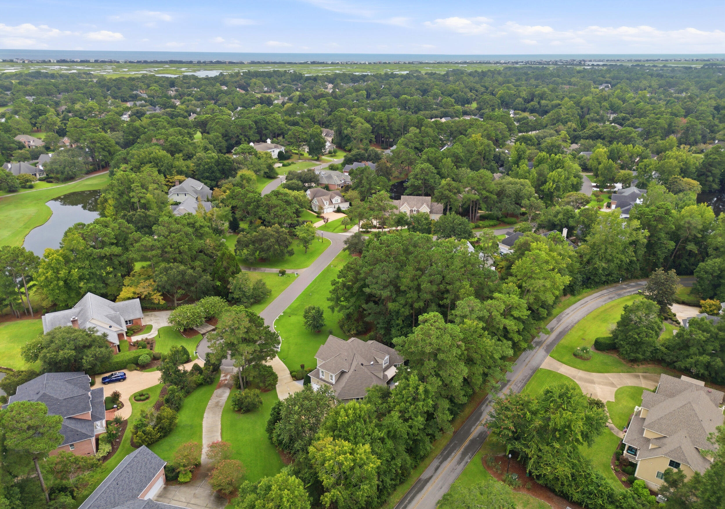 Tree-lined streets and homes in Porters Neck Plantation with the coast beyond