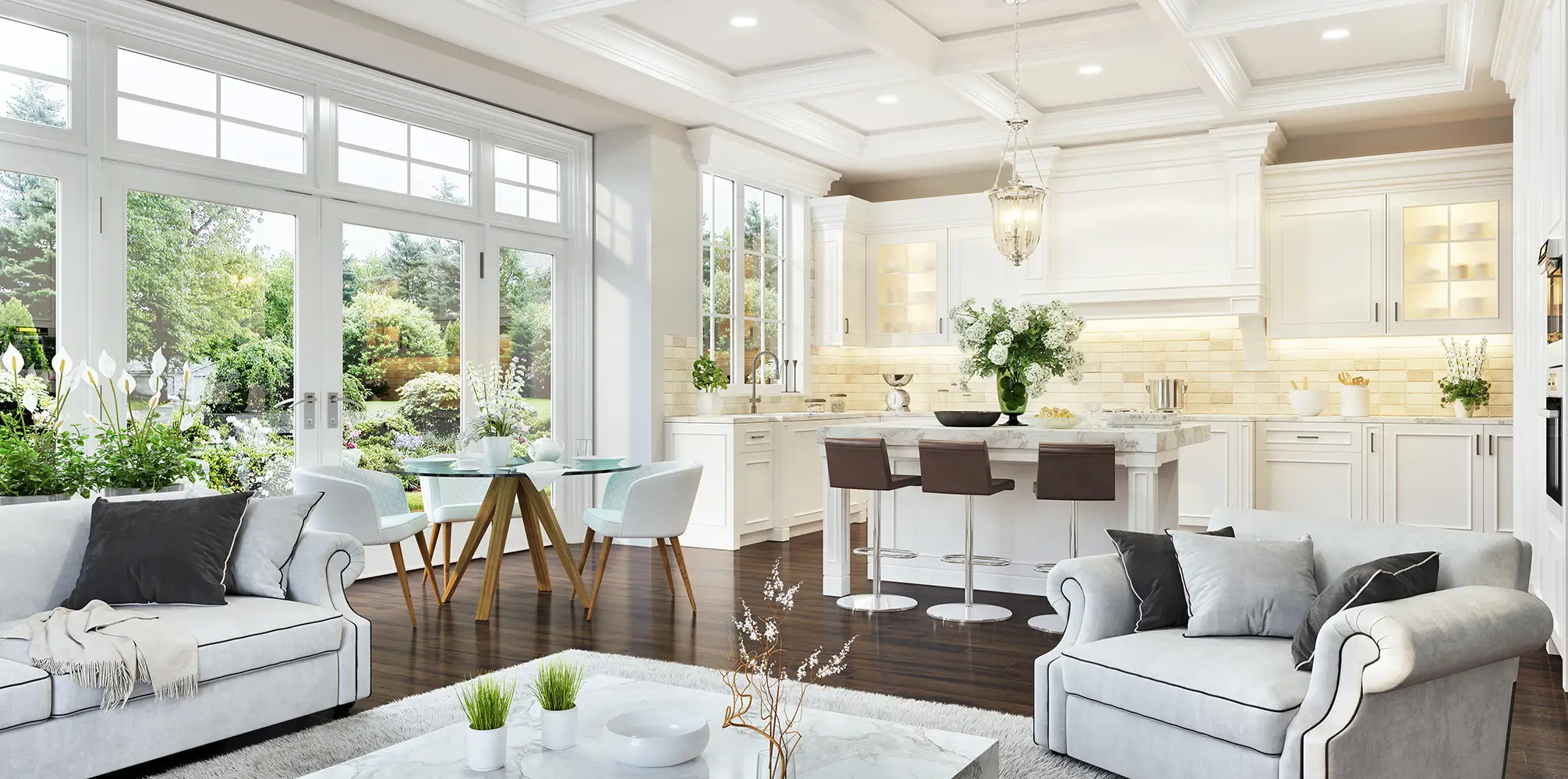 A bright open living room and kitchen with white cabinetry and garden views